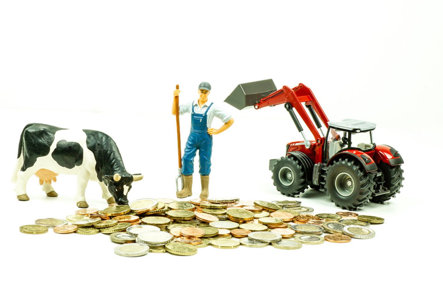 © Countrypixel - stock.adobe.com Foto: Figur von Kuh, Landwirt und Traktor auf Münzen