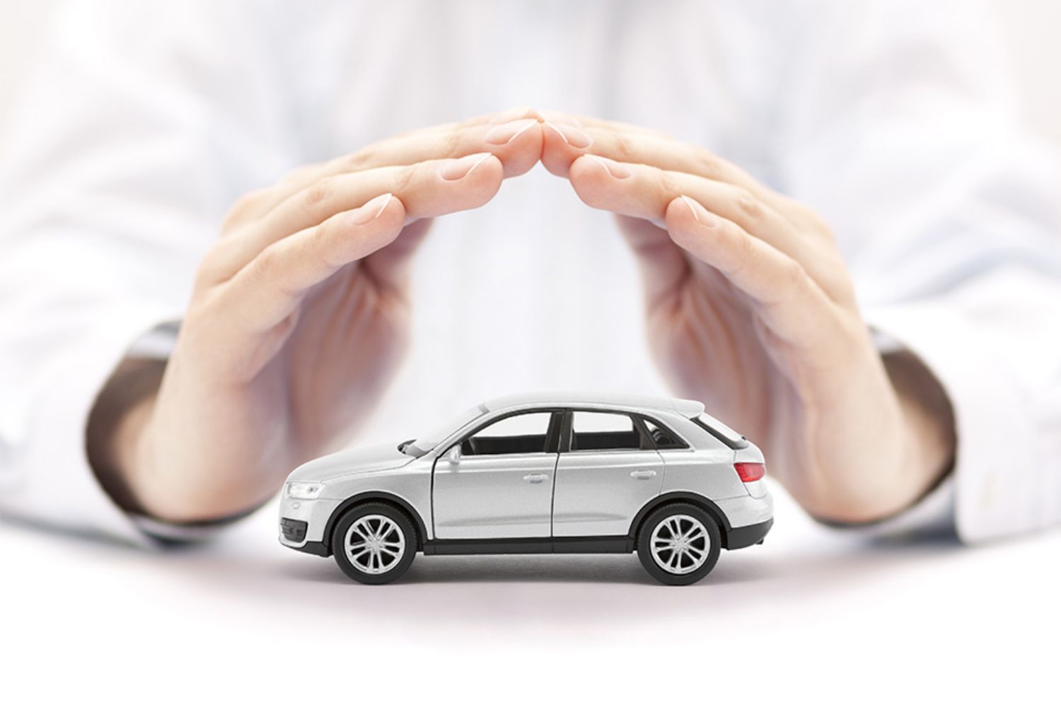 © Jakub Krechowicz - stock.adobe.com Foto: Hände über kleinem Auto